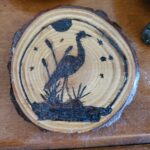 Hobbies and habits showing a crane among cat tails done with pyrography
